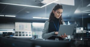A professional woman focused on her laptop screen, analyzing data to optimize a modern channel partner ecosystem.